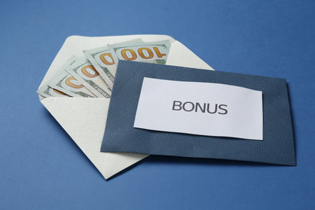 Envelopes with word Bonus and money on blue background, closeupの写真素材
