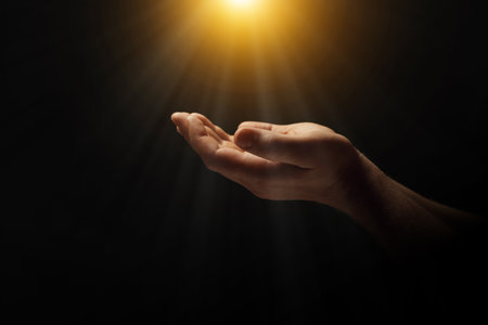Man illuminated by holy light praying in darkness, closeupの写真素材