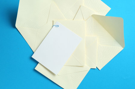 Blank invitation card and envelopes on light blue background, flat lay. Space for design
