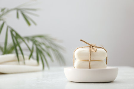 Soap bars on white table against gray background, closeup. Space for textの写真素材