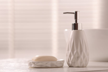 Soap bar and bottle of cosmetic product on white countertop indoorsの写真素材
