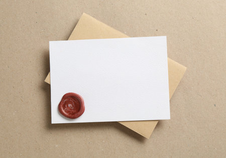 Blank invitation card with wax seal and envelope on carton, top view. Space for designの写真素材