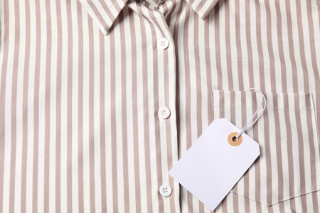 Cardboard tag on striped shirt, top view