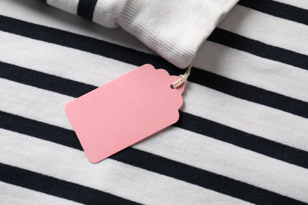 Cardboard tag on striped garment, top viewの写真素材