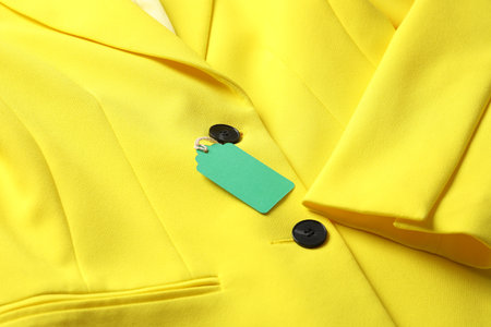 Cardboard tag on yellow jacket, closeup viewの写真素材