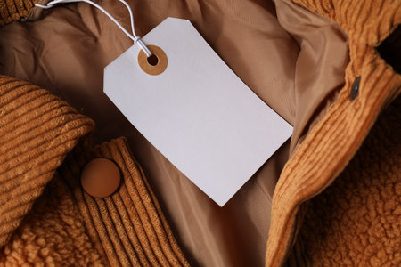 Cardboard tag on brown garment, top viewの写真素材