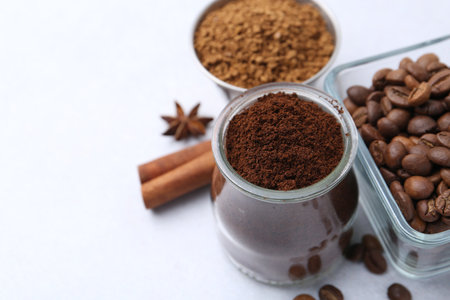 Different types of instant coffee, beans and spices on light table, closeup. Space for textの写真素材