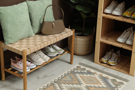 Different footwear on shelves in entryway. Shoe storage