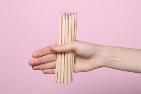 Woman with graphite pencils on pink background, closeupの写真素材