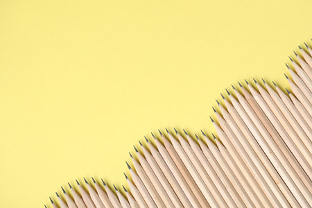 Many graphite pencils on yellow background, flat lay. Space for textの写真素材
