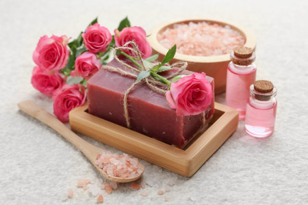 Soap bar, sea salt and beautiful roses on beige table, closeupの写真素材