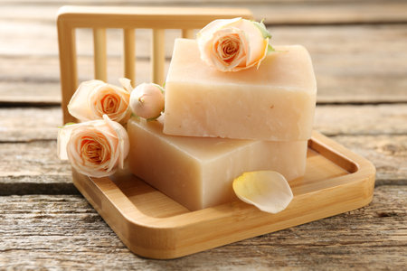 Soap bars and beautiful roses on wooden table, closeupの写真素材