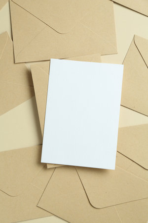 Blank invitation card and envelopes on beige background, flat lay. Space for designの写真素材