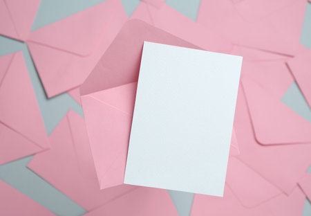 Blank invitation card and envelope on glass surface, top view. Space for designの写真素材