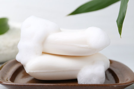 Soap bars with foam on white table, closeupの写真素材