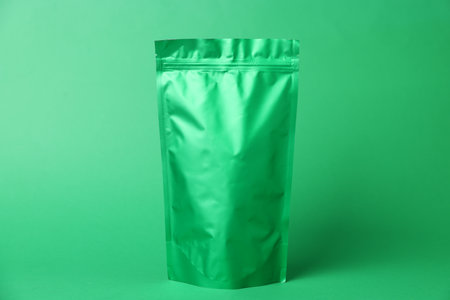 One zipper stand-up pouch on green background. Mockup for designの写真素材