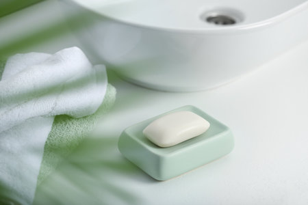 Soap bar and towels on white countertop indoors, closeupの写真素材