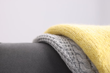 Color wool sweaters on armchair against light background, closeupの写真素材