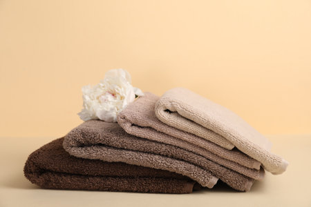 Soft towels and peony flower on beige backgroundの写真素材