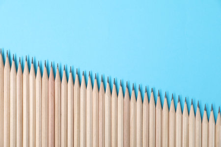 Many graphite pencils on light blue background, flat lay. Space for textの写真素材