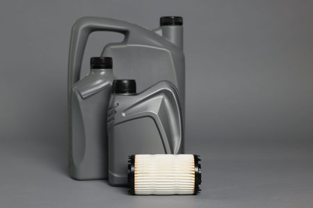 Motor oil in plastic canisters and filter on gray background, space for textの写真素材
