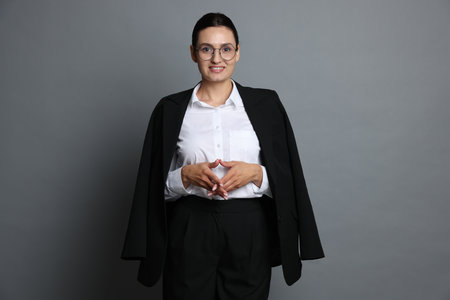 Confident business woman in suit on gray backgroundの写真素材