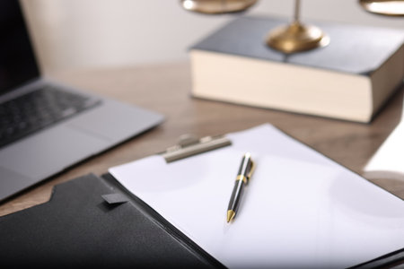 Judge. Laptop, clipboard, pen, book and scales on wooden table in office, closeupの写真素材