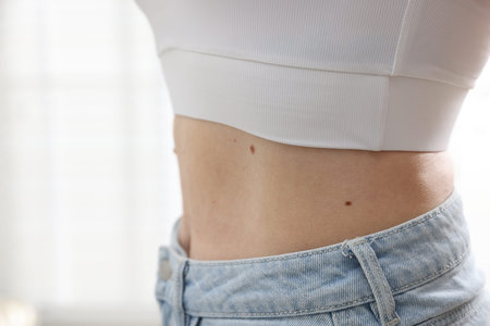 Woman with moles on her body indoors, closeup