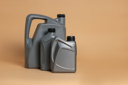 Motor oil in plastic canisters on beige background, space for textの写真素材