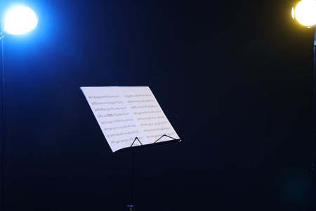 Stand with music sheets on dark background, space for textの写真素材