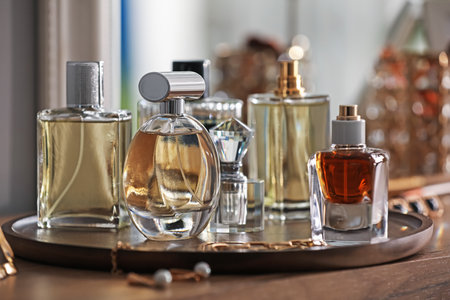 Bottles of different perfumes and accessories on wooden table, closeupの写真素材