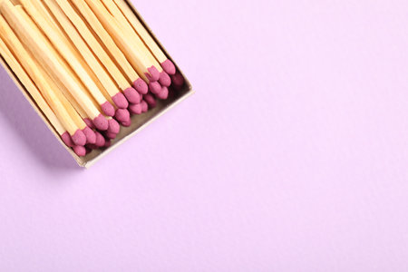 Matches in open box on violet background, top view. Space for textの写真素材