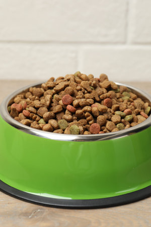 Dry pet food in feeding bowl on floor, closeupの写真素材