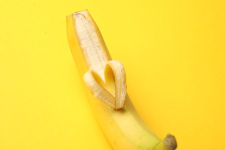 Banana with heart made of peel on yellow background, closeupの写真素材