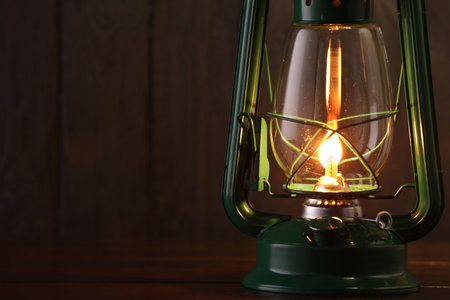 Vintage kerosene lamp on wooden table, closeup. Space for textの写真素材