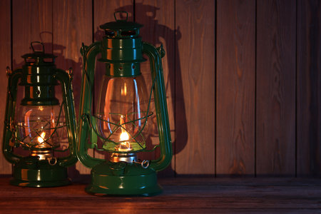 Vintage kerosene lanterns on wooden table, space for textの写真素材