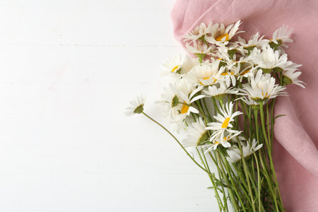Many beautiful chamomile flowers on white wooden table, flat lay. Space for textの写真素材
