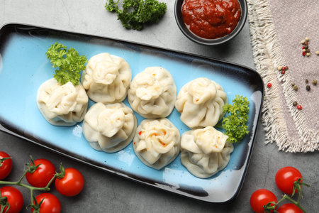Delicious khinkali served on grey table, flat lay