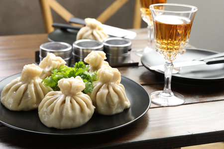 Delicious khinkali served with cilantro and wine on wooden table, closeupの写真素材