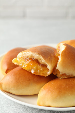 Tasty baked patties with orange jam on light grey table, closeupの写真素材