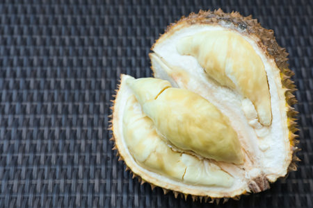 Fresh ripe durian on wicker table, closeup. Space for text