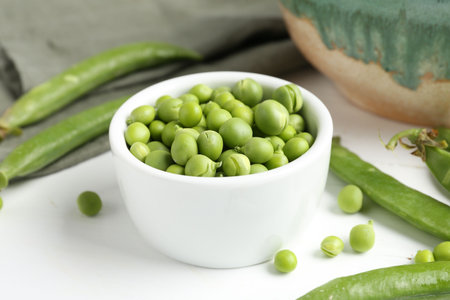 Fresh ripe green peas on white wooden table, closeupの写真素材