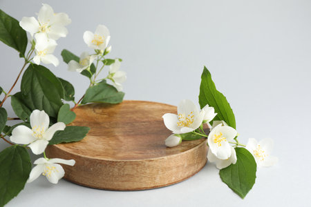 Beautiful jasmine flowers with leaves on light background, closeup. Space for textの写真素材