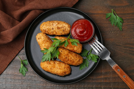 Tasty fried croquettes, parsley and sauce on wooden table, flat layの写真素材