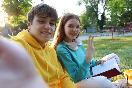 Teenage girl and boy taking selfie together in park
