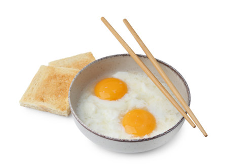 Half-boiled eggs in bowl, toasted bread and chopsticks isolated on white. Traditional asian breakfastの写真素材