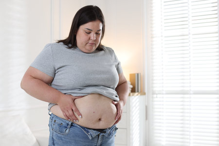 Woman indoors, space for text. Overweight problem