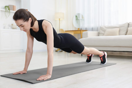 Woman doing plank exercise at home. Sport and healthy lifestyle