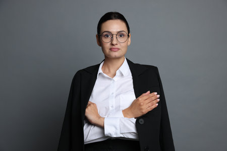 Confident business woman in suit on grey backgroundの写真素材