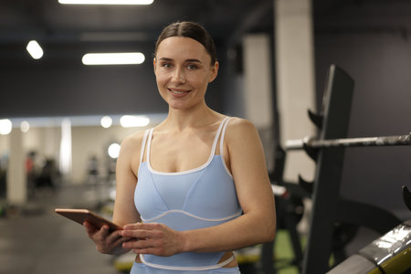 Professional personal trainer with tablet in gymの写真素材
